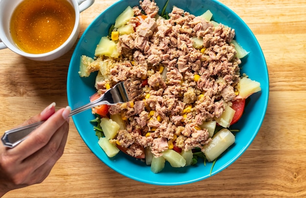 Salade de thon diète avec légumes et sauce d'assaisonnement sur le côté.