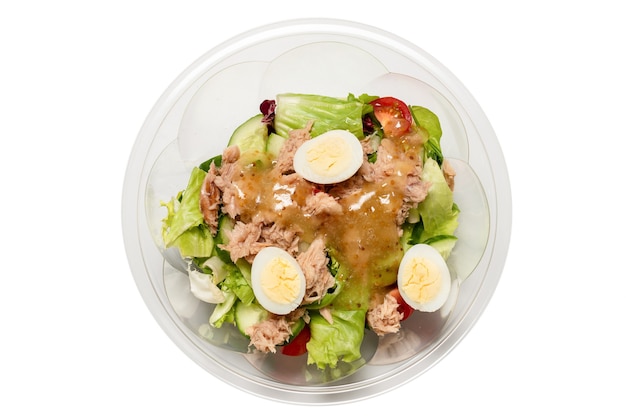 Salade de thon frais avec laitue, concombres, cerises et œufs dans un récipient en plastique. Vue de dessus.