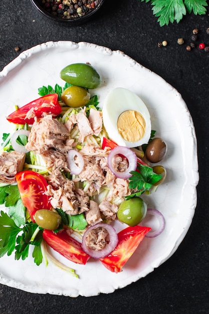 Salade de thon légumes fruits de mer tomates olives thon en conserve assiette de poisson sur la table repas sain