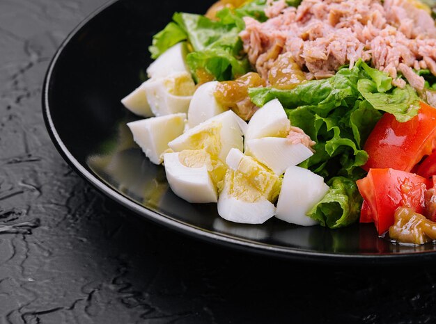 Salade de thon et légumes sur plaque noire