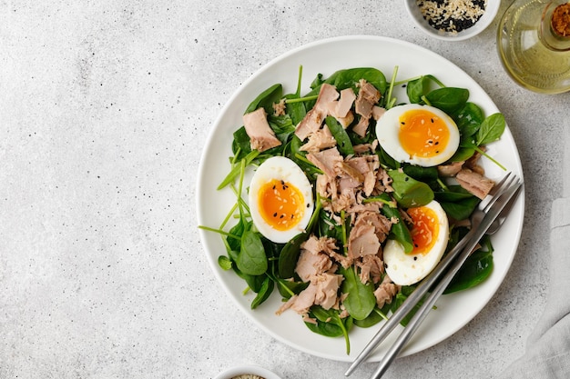 Salade de thon avec œuf à la coque et épinards sur plaque blanche Régime Keto aliments sains Saladier frais