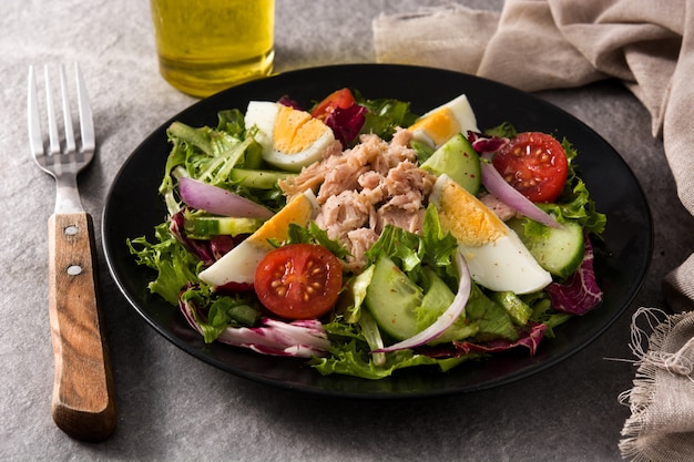 Salade de thon, oeuf et légumes sur plaque noire