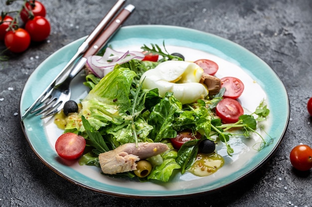 Salade de thon avec oeuf poché, laitue, cerise, tomates olives et maïs