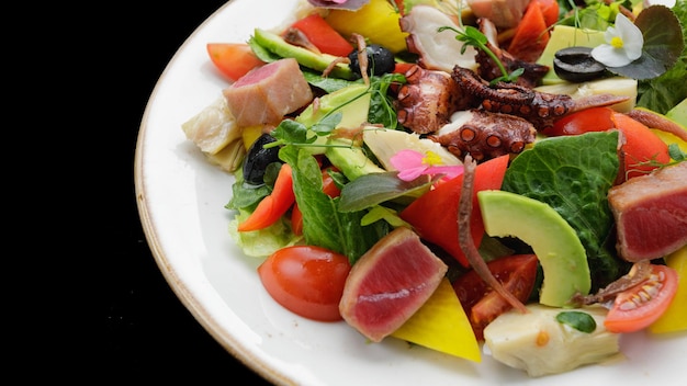 Salade de thon poulpe et légumes sur fond sombre