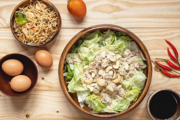 Salade de thon et spaghetti épicé au café noir sur fond de bois nature