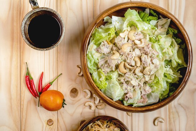 Salade de thon et spaghetti épicé au café noir sur fond de bois nature