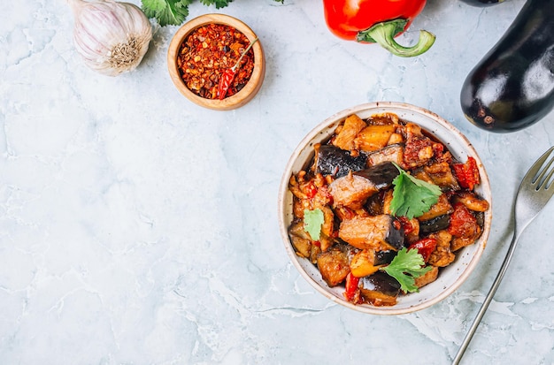 Salade tiède d'aubergines et de poulet sur fond de marbre gris