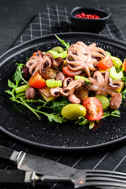 Salade tiède de poulpe, pommes de terre, roquette, tomates et olives.