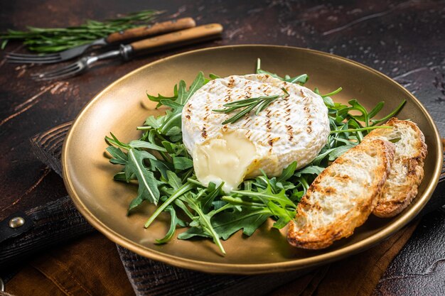 Salade avec toast de roquette au camembert grillé et romarin dans une assiette Fond sombre Vue de dessus