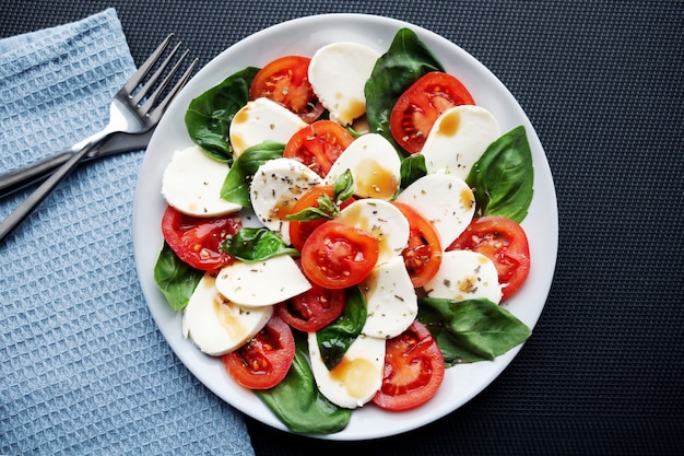 Salade de tomates, basilic, mozzarella caprese au vinaigre balsamique et huile d'olive.