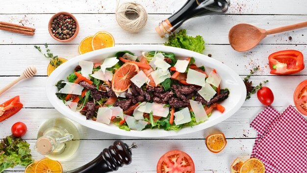 Salade de tomates épinards de veau et de parmesan Sur un fond en bois Vue de dessus Espace de copie gratuit