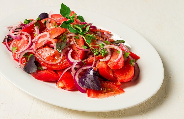 Salade de tomates fraîches avec des épices d'oignon rouge et des herbes vue de haut gros plan fait maison