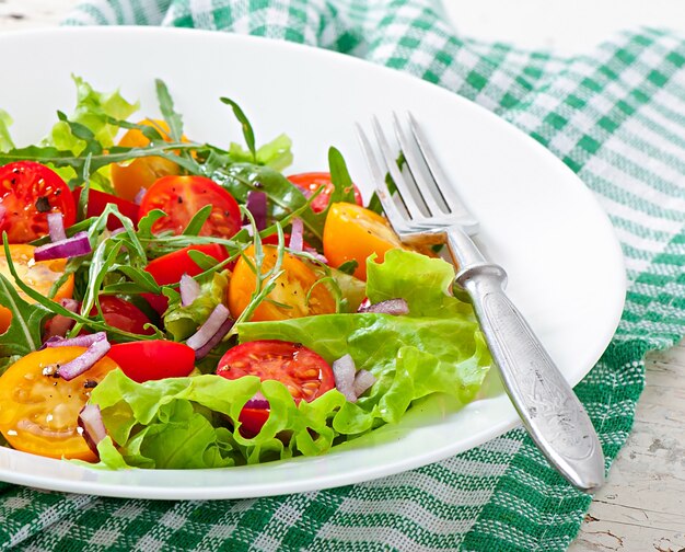 Salade de tomates avec laitue, arugala et oignons