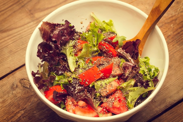 Salade de tomates et de laitue aux graines de chia dans un bol blanc