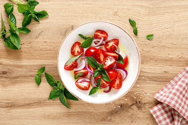 Salade de tomates à l'oignon basilic frais et vue de dessus d'huile d'olive