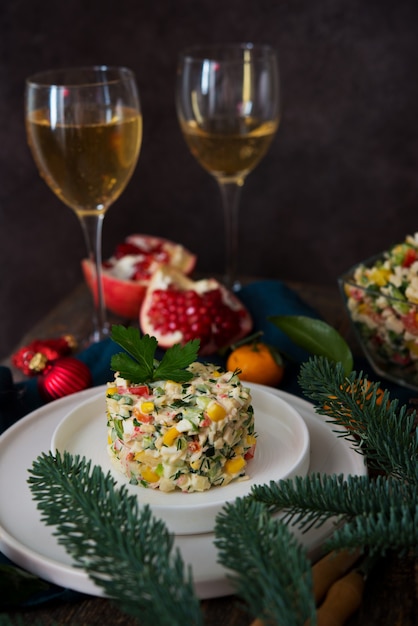 Salade de vacances du Nouvel An avec mayonnaise, table du Nouvel An, champagne, gros plan