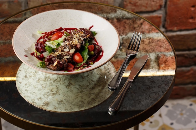 Salade de veau et tomates Steak de boeuf avec mélange de crudités vue latérale Viande grillée avec garniture gros plan Délicieux plat principal sur table