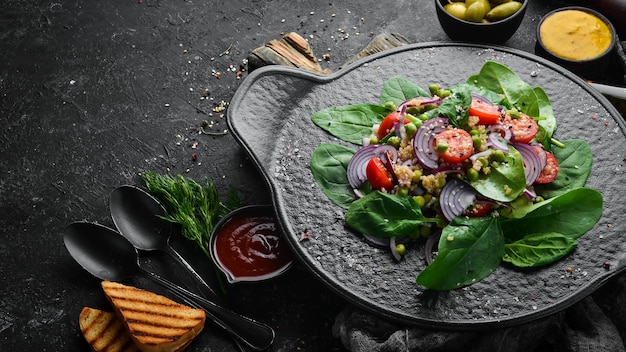 Salade végétalienne saine d'épinards quinoa tomates et légumes Vue de dessus Style rustique