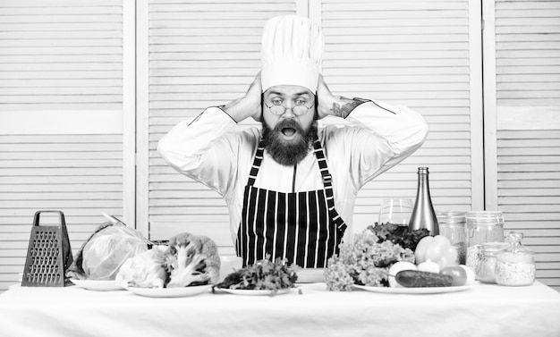 Photo salade végétarienne aux légumes frais cuisine saine hipster mature avec barbe cuisine culinaire régime vitaminique aliments biologiques recette de chef homme barbu choqué nouveaux arrivants