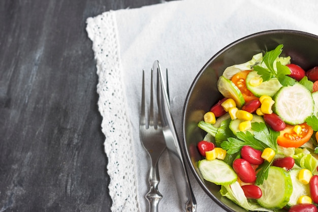 Salade végétarienne avec haricots rouges mexicains, maïs, roquette, tomates cerises et huile d&#39;olive