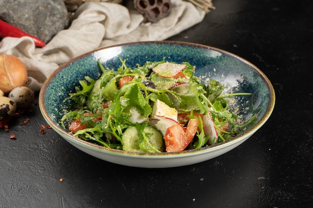 Salade végétarienne avec radis, roquette, tomates, concombre, œuf et parmesan.