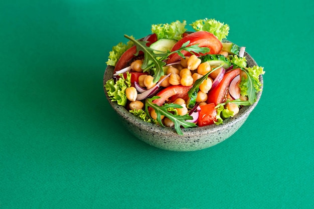 Salade végétarienne saine de pois chiches dans un bol avec des herbes de légumes et une vinaigrette