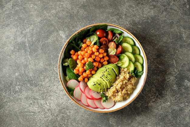 Salade végétarienne saine avec pois chiches, quinoa, concombre, radis et avocat