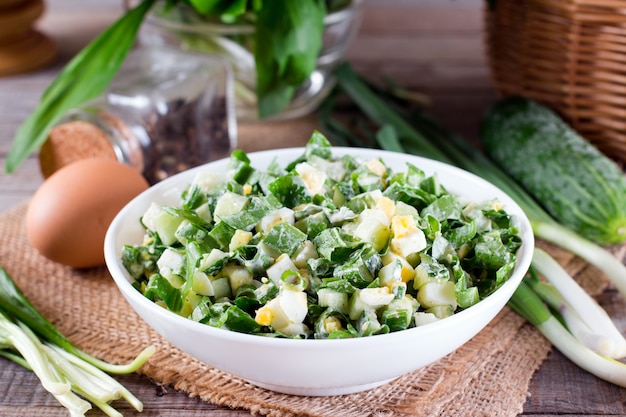 Salade verte aux oignons et oeufs sur une table