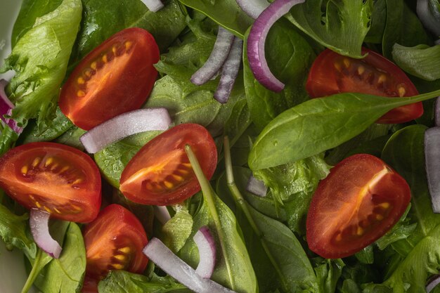 Photo salade verte d'été dans une assiette de bol blanc sur une table grise