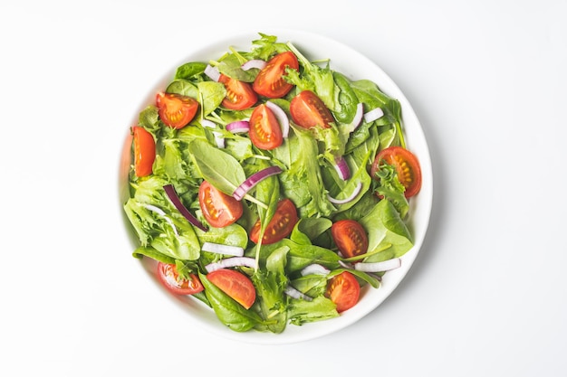 Photo salade verte d'été dans une assiette de bol blanche sur une table grise