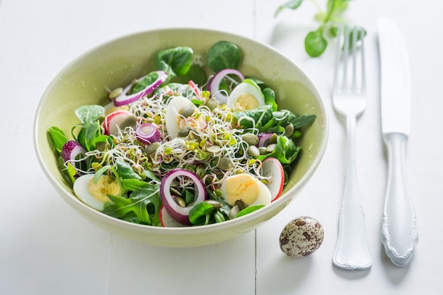 Salade verte fraîche avec œuf de caille à l'oignon et germes