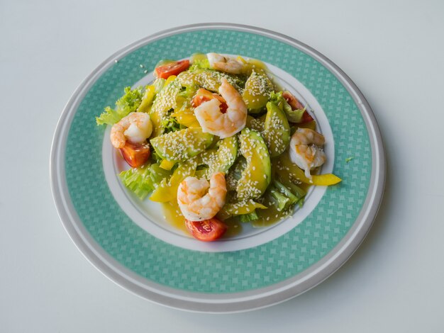 Salade verte légère aux crevettes et avocat sur une assiette.