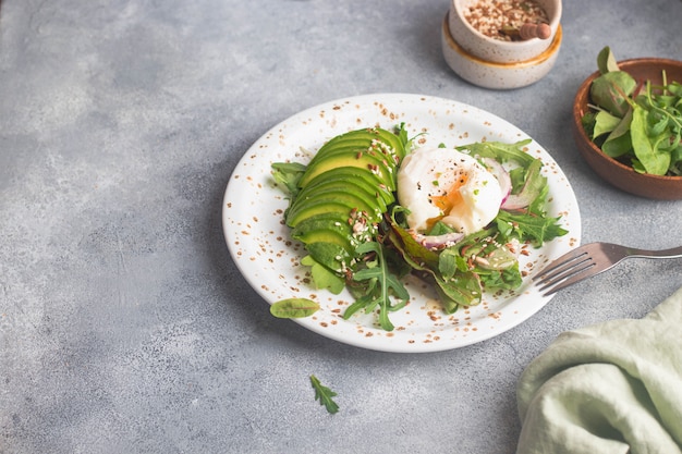 Salade verte à la roquette, avocat, oignon, lin poché et graines de sésame, huile d'olive