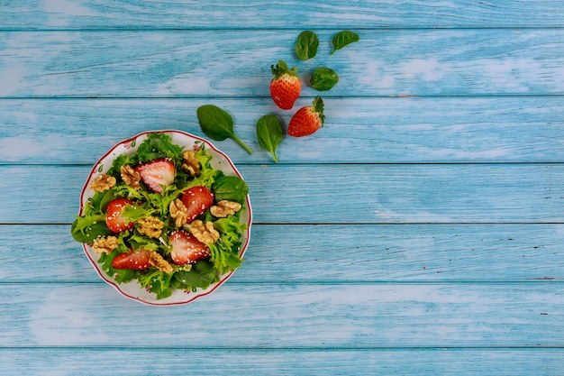 Salade verte saine avec fraise, noix et graines de sésame.