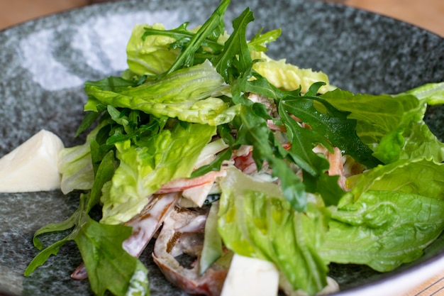 Salade verte végétalienne de mélange de feuilles vertes, légumes et tofu. Flou sélectif.