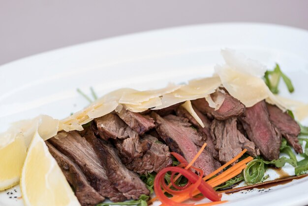 Salade de viande grillée, servie avec parmesan et rucola