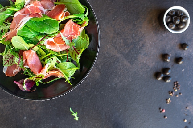 Salade viande jambon prosciutto feuilles vertes mélanger laitue olives légumes collation