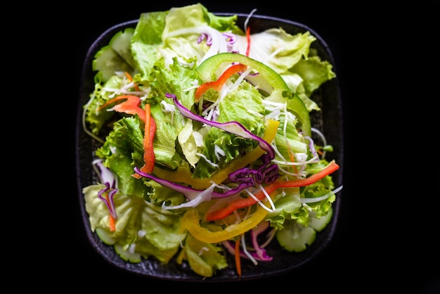 Salade vietnamienne fraîche avec des légumes sur la vue de dessus de fond noir