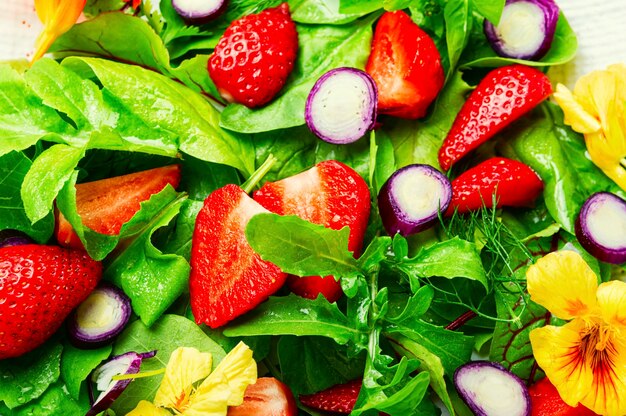 Salade de vitamines aux fraises, épinards, capucines et roquette. Salade d'été colorée. Fond de nourriture