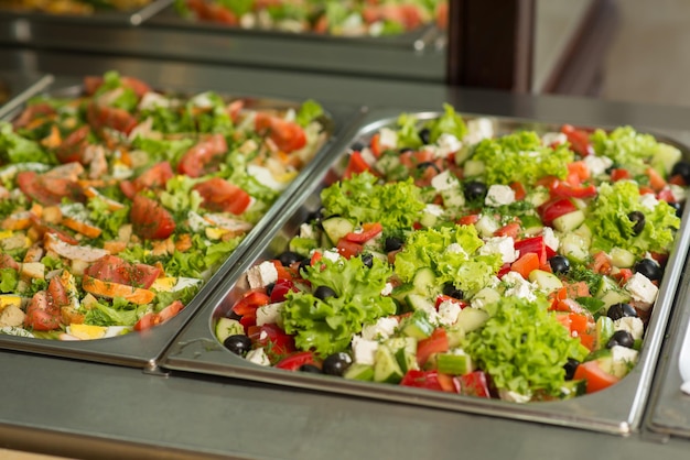 Salades fraîches dans des chaudières sur la table du buffet