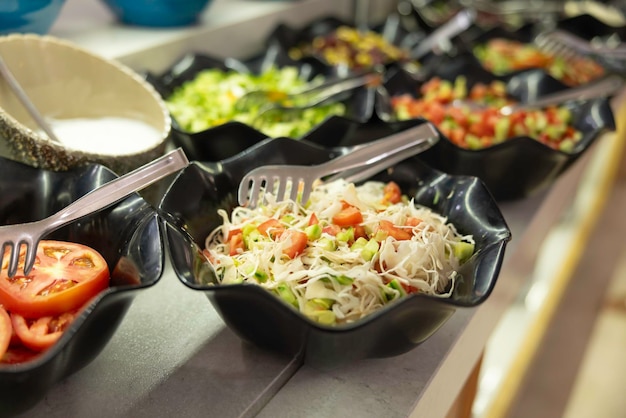 Salades de légumes frais dans des bols sur la table du buffet du restaurant de l'hôtel