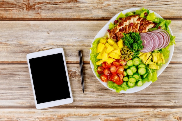 Salades santé avec tablette et stylo sur table en bois