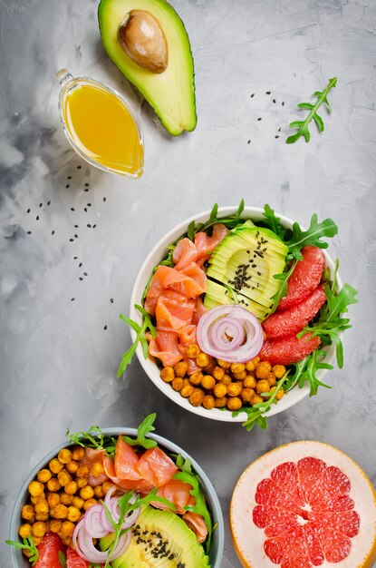 Saladier sain avec saumon, pamplemousse, pois chiches épicés, avocat, oignon rouge et roquette