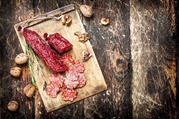 Salami aux épices et aux noix. Sur un fond en bois.