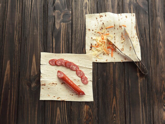 Salami fumé avec du pain pita sur fond de bois