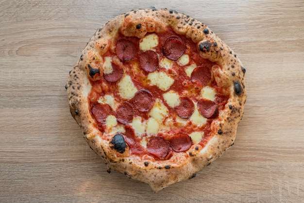 Photo salami italien pepperoni pizza pâte fermentée croûtes cuites au four napolitain gros plan vue de haut