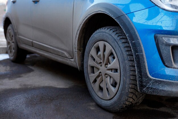 Saleté et poussière sur la carrosserie et les roues d'une voiture chimie et sel