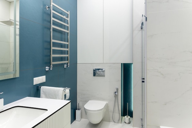 Salle de bain bleu et blanc avec toilette grand miroir cabine de douche éclairage et vasque à poser