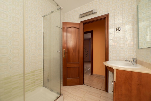 Salle de bain avec cabine de douche en verre de meubles en bois et portes en bois foncé