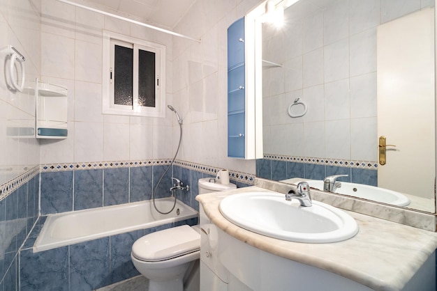 Salle de bain avec carrelage en marbre sur les murs aux couleurs contrastées bleu en bas et blanc en haut